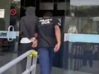 Adolescente que, segundo a polícia, confessou ter matado os pais e o irmão é conduzido por policial civil na delegacia de Itaperuna-RJ. 