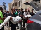 Imagem mostra palestinos carregando corpos de vítimas de um ataque israelense próximo a um centro de distribuição de ajuda humanitária nesta segunda-feira, 30, na Faixa de Gaza 