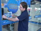 Cláudio Mendonça, presidente do Sebrae/MS, fixa selo do Movimento de Rua na vitrine da Ótica Nova Visão, em ação de apoio ao comércio local.