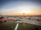 Vista panorâmica do pátio da Base Aérea de Campo Grande ao entardecer, com aeronaves militares posicionadas.