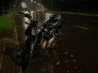 Motocicleta danificada após queda em madrugada chuvosa em Campo Grande (MS); veículo foi removido para o pátio do Detran