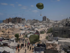 Palestinos correm para coletar ajuda humanitária lançada de paraquedas na Cidade de Gaza, no norte da Faixa de Gaza, em 7 de agosto de 2025. 