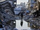 Palestinos caminham entre os escombros em Gaza