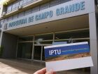 Contribuinte segura carnê do IPTU em frente à sede da Prefeitura de Campo Grande; nova proposta do Executivo prevê mudanças na forma de cobrança do imposto na capital sul-mato-grossense.