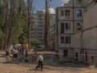 Pessoas se reúnem ao lado de flores, brinquedos infantis e retratos colocados em memória das vítimas no local de um prédio residencial de nove andares destruído após um recente ataque com mísseis russos em Kiev, em 5 de agosto de 2025
