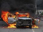 Um carro pega fogo em frente ao Singha Durbar, o principal prédio administrativo do governo do Nepal, em Katmandu, em 9 de setembro de 2025