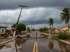 Rua alagada com postes caídos depois de um temporal. A imagem mostra os efeitos do vento forte em cidades do interior de Mato Grosso do Sul.