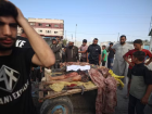 Palestinos reagem ao lado dos corpos de pessoas em outro ataque nesta sexta (26) 