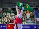 Maria Clara Pacheco ergue a bandeira do Brasil após conquistar o título mundial de taekwondo na China