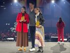 Lucimar Amaral, da LuChurros Delícias em Família, recebe o troféu de Melhor Sobremesa do Centro-Oeste no palco do iFood Move 2025, em São Paulo.
