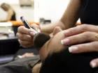 Modelo sendo maquiada em camarim
