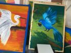 Exposição apresenta 15 obras criadas por crianças PCDs em aulas de arteterapia, com representações coloridas da fauna pantaneira.