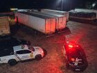 Viaturas da Polícia Civil e da Polícia Científica cercam carretas estacionadas no pátio do Posto Caravágio, na BR-163, em Campo Grande, durante atendimento à ocorrência que resultou na localização do corpo de um caminhoneiro.