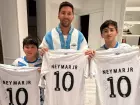 Lionel Messi e dois de seus filhos seguram a camisa do Santos autografada por Neymar, em foto compartilhada pelo clube nas redes sociais.