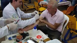 Estudante de medicina da UEMS realiza exame de sangue em caminhoneiro durante ação do projeto 