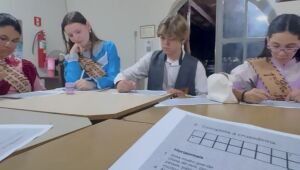 Participantes da oficina cultural em Dourados, interagindo com o novo livro da ALEMS e aprendendo sobre o folclore regional.