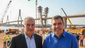 Reinaldo Azambuja e Eduardo Riedel em montagem sobre as obras da ponte internacional entre Porto Murtinho (Brasil) e Carmelo Peralta (Paraguai), símbolo da Rota Bioceânica e marco logístico para o Mato Grosso do Sul.