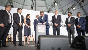 O governador Eduardo Riedel assinando o protocolo acompanhado do governador de São Paulo, Tarcísio de Freitas e o prefeito de São Paulo, Ricardo Nunes, durante o evento em São Paulo.