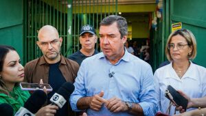 Governador Eduardo Riedel, acompanhado de secretários, fala com a imprensa durante visita à escola em Campo Grande.