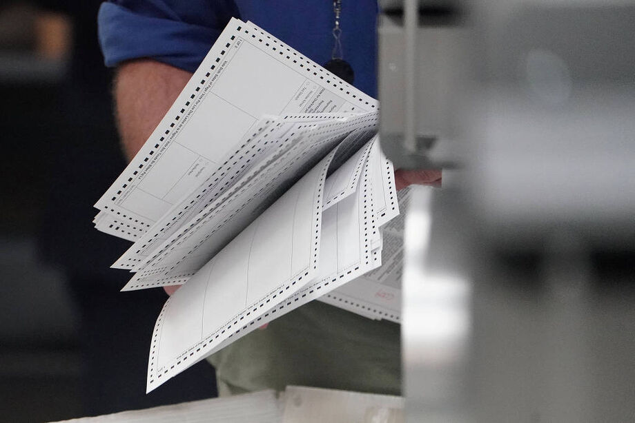 Funcionário da comissão eleitoral segura cédulas durante recontagem dos votos em Lauderhill, na Flóirda