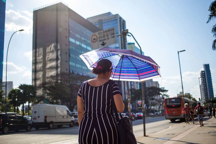 Altas temperaturas obrigam pedestres a usarem sombrinhas para se protegerem do sol