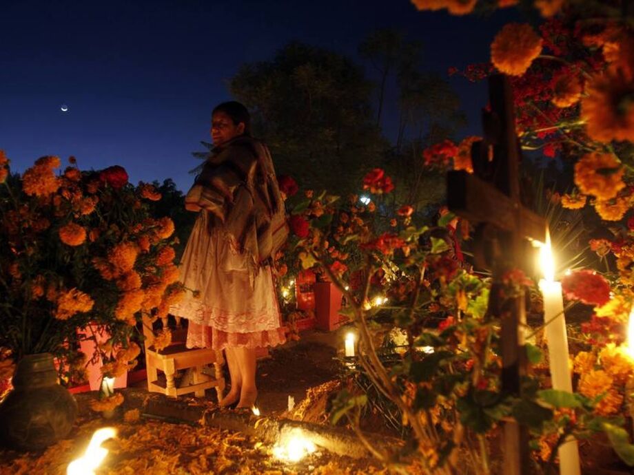 Mexicanos decoram os túmulos dos familiares e passam o dia no cemitério.