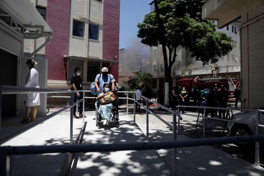 Paciente sendo retirada de cadeiras de rodas após incêndio que atingiu Hospital Federal de Bonsucesso