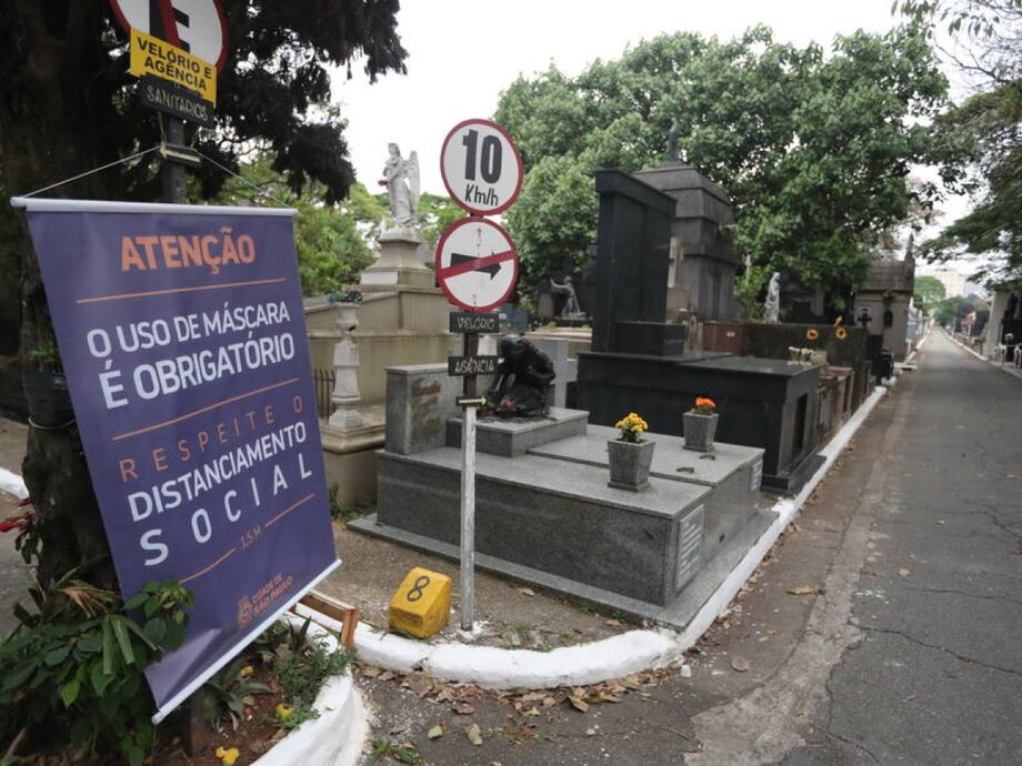 Banner com os cuidados a serem tomados durante a visitação em frente ao cemitério
