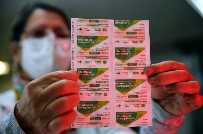 Profissional da saúde exibe tabletes de cloroquina disponíveis em farmácia