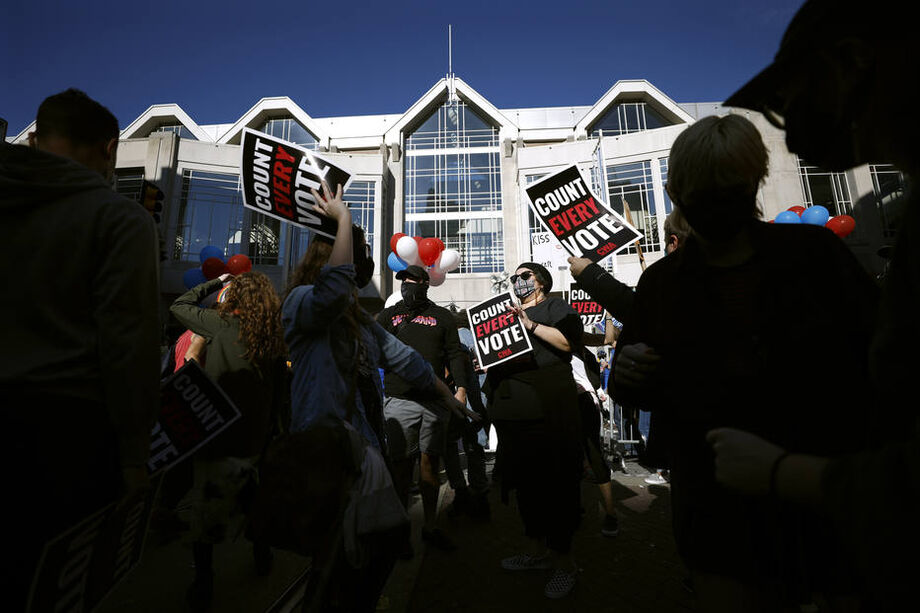 Eleitores de Biden dançam em manifestação em apoio a Joe Biden em frente ao local onde se apuram os votos