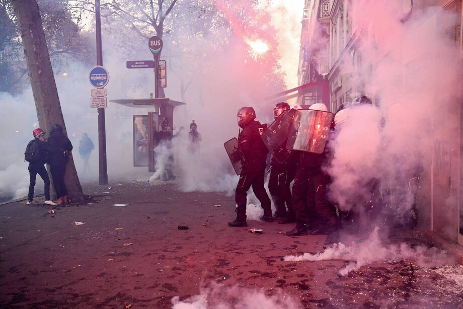 Policiais em meio à fumaça de bombas de gás durante confronto com manifestantes em Paris