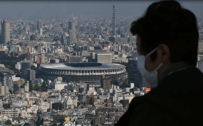 Homem observa o Estádio Nacional de Tóquio, principal palco dos Jogos Olímpícos de 2021