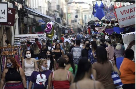 Pessoas caminham em rua comercial popular em meio ao surto da doença coronavírus