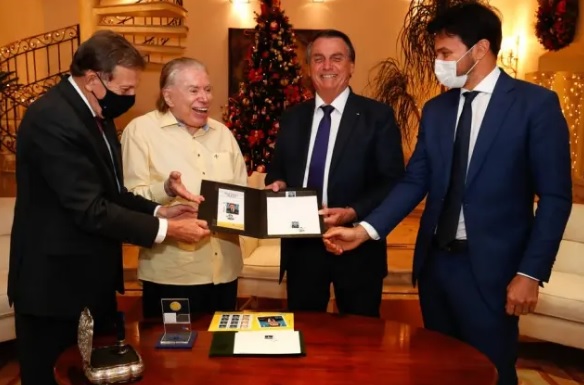Floriano Peixoto Neto, presidente dos Correios, Silvio Santos, Jair Bolsonaro e Fabio Faria, ministro das comunicações e genro do apresentador, durante cerimônia por conta de selo comemorativo aos 90 anos do dono do SBT