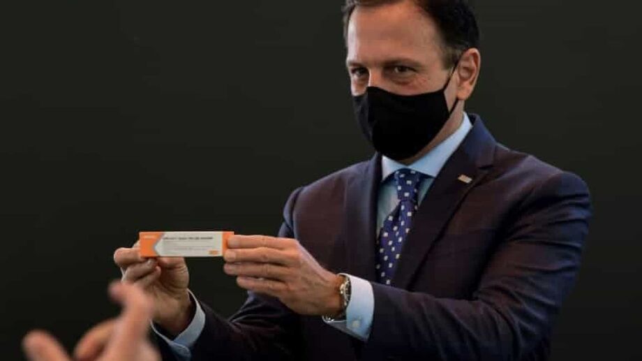 Governador João Dória segurando embalagem da Coronavac