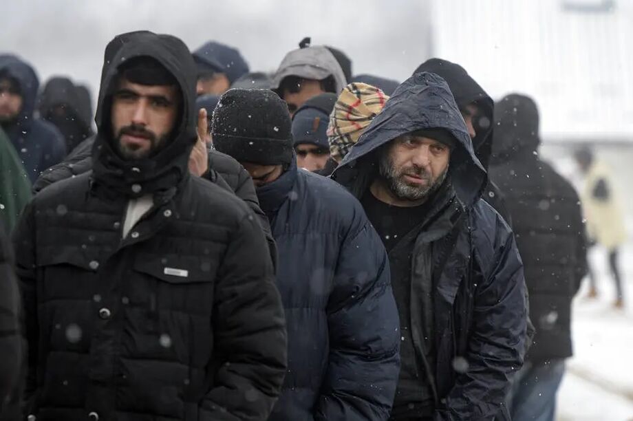 Migrantes aguardam em fila sob neve para receber comida em Bihac, Bósnia