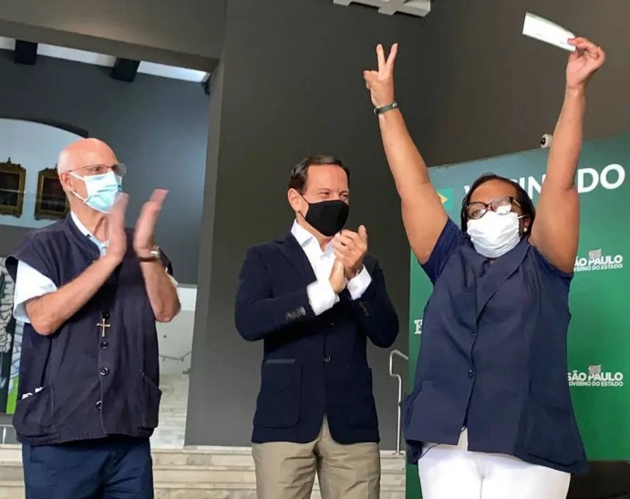 Acompanhado do padre Julio Lancellotti, o governador João Doria acompanha vacinação da segunda dose da Coronavac à enfemeira Monica Calazans nesta sexta, 12