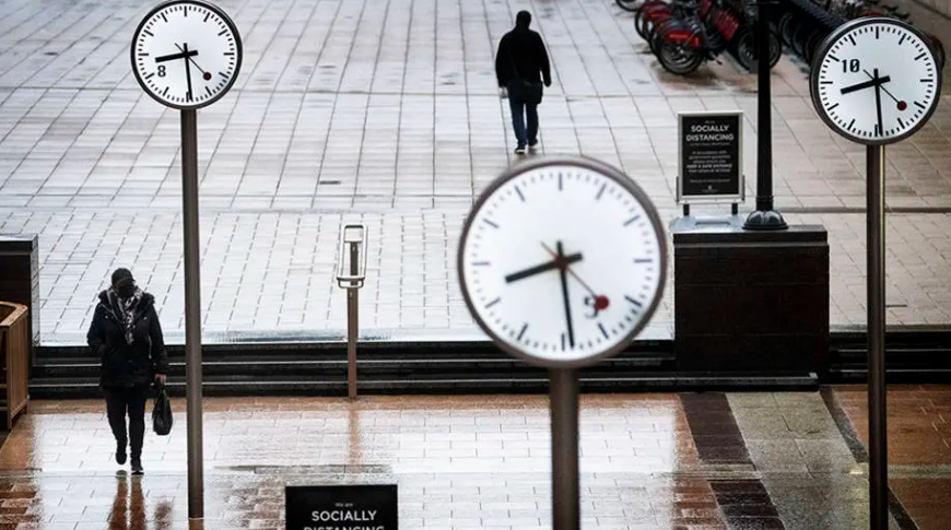 Pessoas caminham pelas ruas desertas do Canary Wharf, devido ao lockdown para conter a disseminação do Covid-19, em Londres