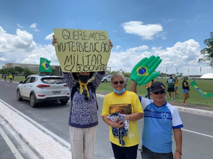 Manifestante mostra cartaz pedindo intervenção militar durante ato em Brasília.