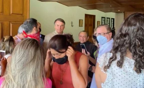 Bolsonaro sem máscara cumprimentando os fiéis