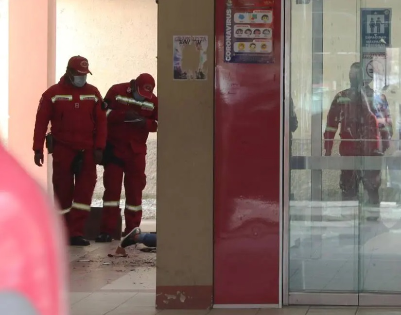Bombeiros diante de corpo de vítima de acidente em universidade de El Alto, na Bolívia