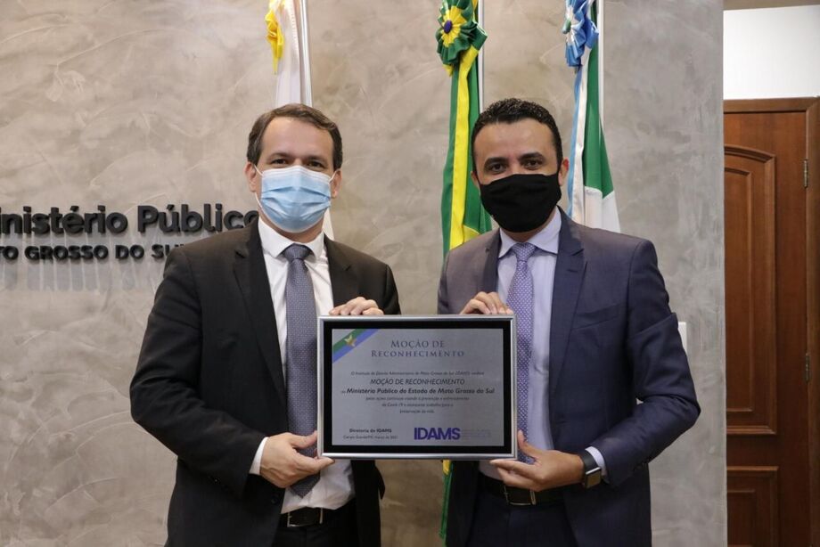 O procurador-geral de Justiça de Mato Grosso do Sul Alexandre Magno Benites de Lacerda recebe congratulação das mãos do  presidente do IDAMS, João Paulo Lacerda da Silva
