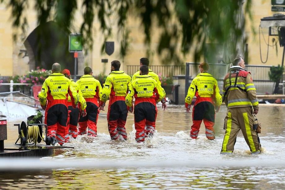 Equipe de resgate caminha por rua inundada em Valkenburg, Holanda