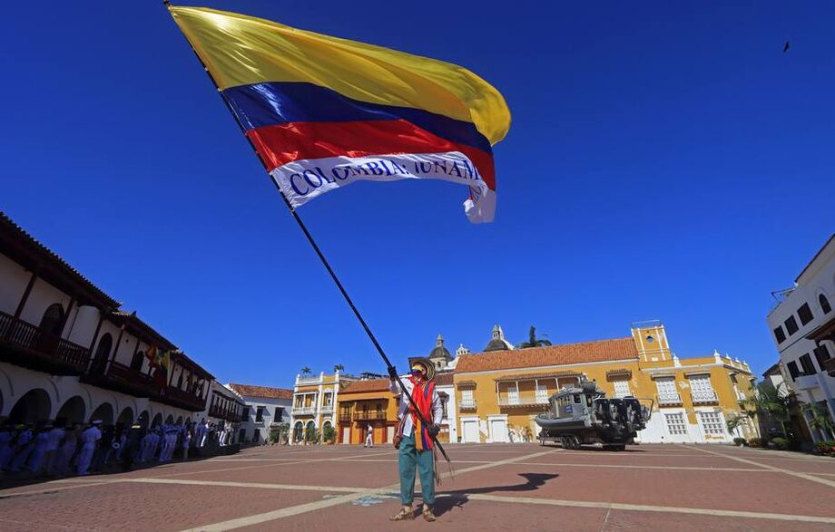 Um homem em traje típico camponês colombiano agita uma bandeira nacional em 20 de julho, durante a comemoração do Dia da Independência no centro histórico de Cartagena