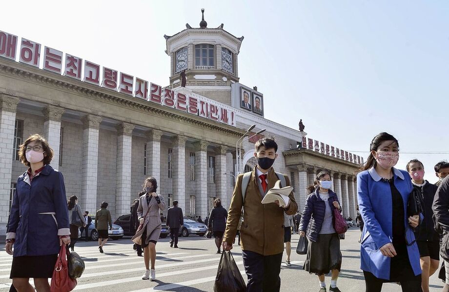 Pessoas usam máscara ao caminhar perto da estação ferroviária de Pyongyang, capital da Coreia do Norte, em 27 de abril