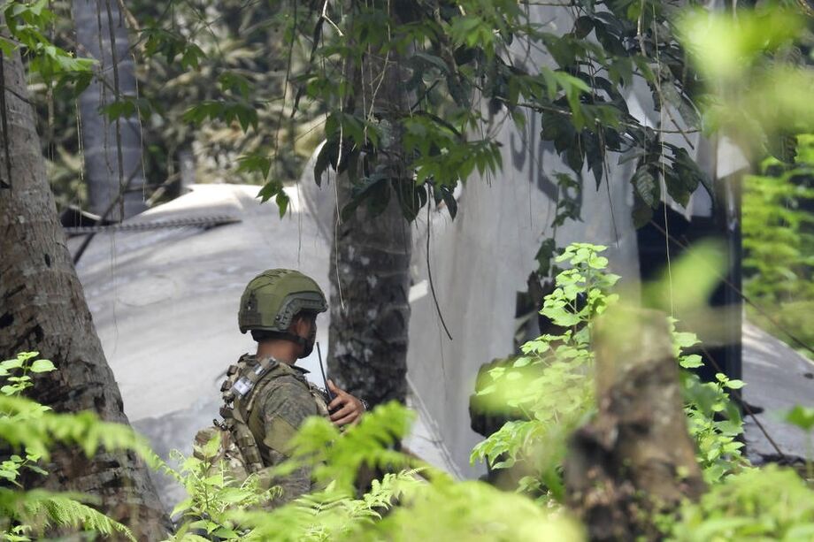 Um soldado protege o perímetro ao lado da cauda de um avião Hércules C-130 no local do acidente, na cidade de Patikul, província de Sulu, sul das Filipinas