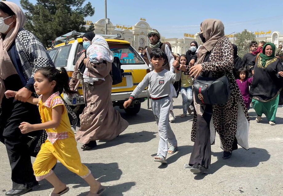 Mulheres levam crianças pelas mãos no Aeroporto Internacional Hamid Karzai, em Cabul, nesta segunda-feira, 16. Foto: REUTERS/Stringer