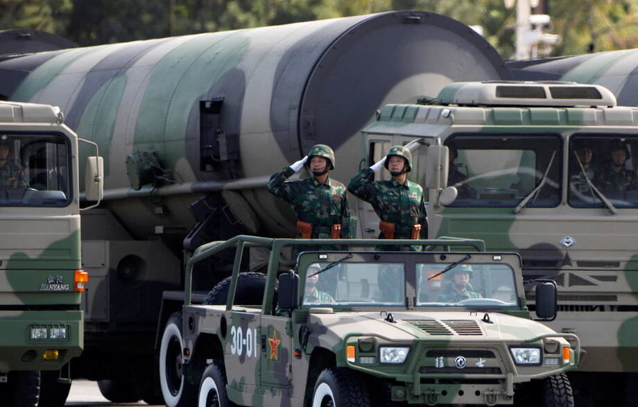 Soldados batem continência em frente a mísseis com capacidade nuclear durante desfile militar em 2009
