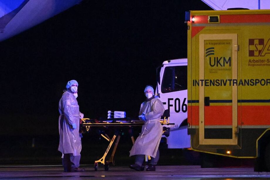 Equipe médica transporta paciente infectado com covid-19 de aeroporto no norte da Alemanha.