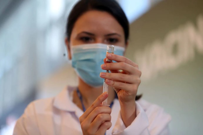 Enfermeira segura vacina contra a covid; Brasil já tem mais de 61% da população total com o esquema vacinal completo (duas doses ou aplicação única)